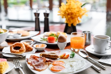 setting of breakfast includes coffee, fresh orange juice, eggs on table in hotel restaurant