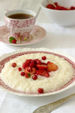 Fototapeta Tulipany - A useful breakfast of rice porridge with strawberry sauce served with tea.