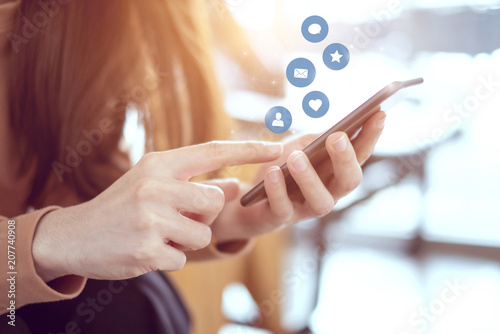 Cuadros en Lienzo Woman hands using mobile smartphone with icon social media and marketing