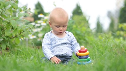 Wall Mural - Little baby boy, playing with big construction blocks in garden, building different shapes