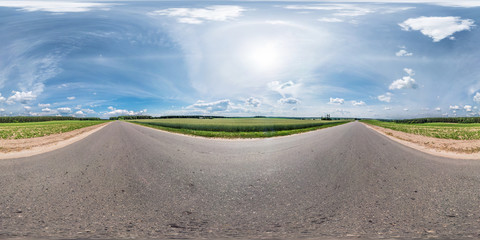 Wall Mural - full seamless spherical panorama 360 by 180 degrees angle view on the asphalt road among fields in sunny summer day with halo in equirectangular projection, skybox VR virtual reality content