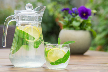 Fresh homemade lemonade with ice and mint on the table.