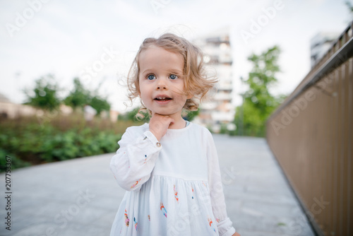 Close Up Portrait Of Cute Little Girl With Curly Blonde Hair In