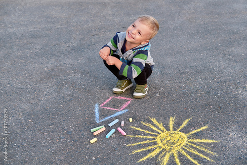 Happy Little Kid Boy Siting On Asphalt Drawing House And Sun Painted By Colored Chalk Creative Leisure Toddler On Outdoors Beautiful Small Child Smiling Looking Away Top View Stock Photo Adobe Stock