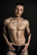 © vladorlov - Sexy man without a shirt. Black background.
