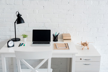 Wall Mural - work desk with laptop at home in front of white brick wall