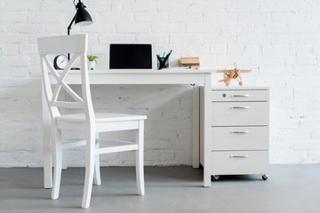 Sticker - modern work desk with laptop at home in front of white brick wall