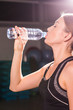 © satura_ - Fitness young woman drinking water from bottle. Muscular young female at gym taking a break from workout.