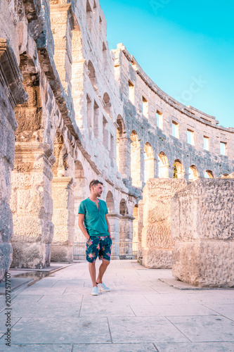 Fotomural young man walking at Roman amphitheatre (Arena) in Pula, Croatia