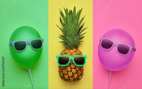 Fototapeta na wymiar Kolorowa wakacyjna tapeta z ananasem i balonami
