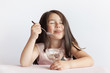 © kaganskaya115 - Happy child girl eating ice cream in white and chocolate bowl on white background. Enjoying delicious.