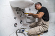 © pavelgulea - specialist male plumber repairs faucet in bathroom