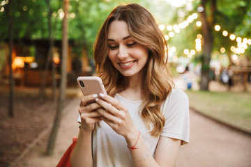 Smiling young girl holding mobile phone