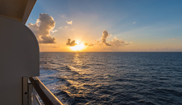 Cruise ship deck at sunset over the Pacific Ocean.