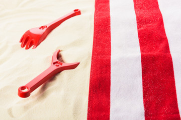 Towel and beach toys on sandy beach