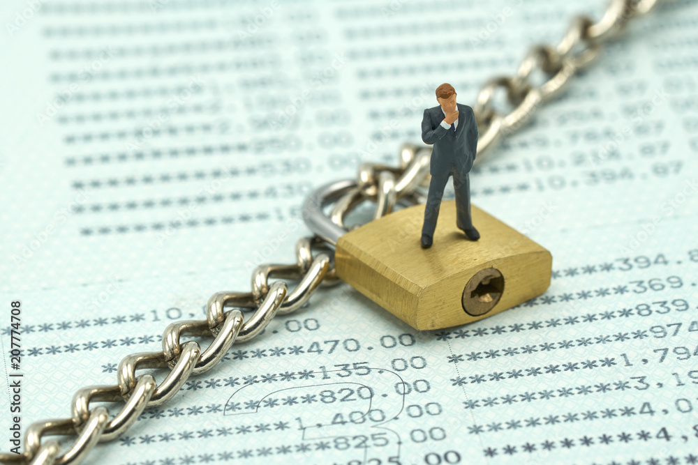 Miniature people  businessmen standing Investment Analysis Or investment Key lock and chain at the bank account lockout concept lock bank financial statement placed on the white space to add text 