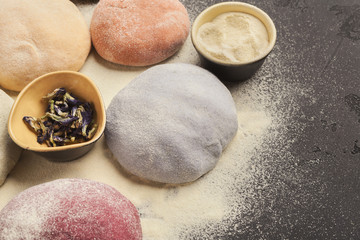 Wall Mural - Colorful fresh pasta dough on black table