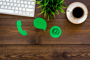 Poster - Customer service concept. Concact information. Phone, message, email signs on office work desk with computer on dark wooden background top view copy space