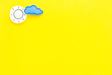 Wall Mural - clear and cloudly weather icons on yellow background top view copy space
