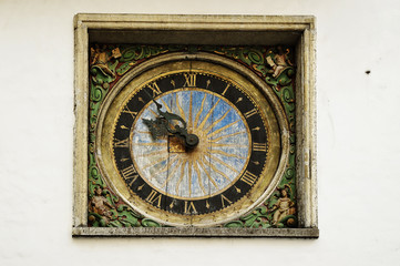 Wall Mural - old clock on the wall of the church in the old town