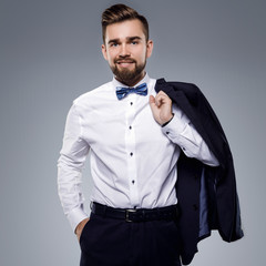 Wall Mural - Stylish handsome man wearing a classic suit with bow-tie