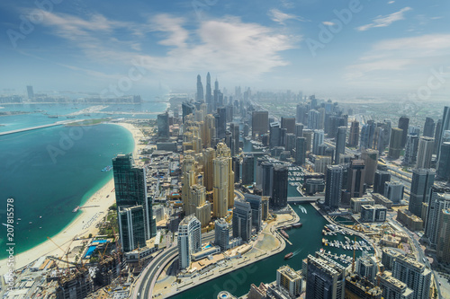 Fototapeta Widok z lotu ptaka nowożytni drapacze chmur i morze w tle w Dubaj, UAE.