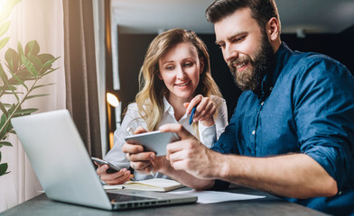 business meeting. teamwork. smiling businesswoman and businessman sitting at table in front of lapto