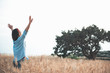 © Yakobchuk Olena - Freedom of mind concept. Back view of gorgeous girl is standing in golden wheat field with raised hands and expressing happiness. Copy space in the right side