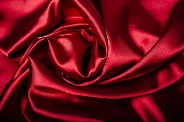 Red fabric in the folds. drapery. shine on silk. Sewing