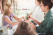 © Yakobchuk Olena - Happy teacher helping girl making plastic toy while talking with her. She holding it in hands