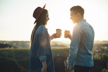 Side View Of Man And Female Drinking Coffee And Spending Time Joyfully During Summer Evening. They Are Looking At Each Other And Smiling