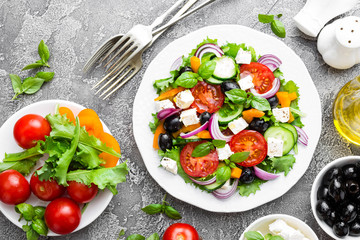 Canvas Print - Greek salad. Fresh vegetable salad with tomato, onion, cucumbers, basil, pepper, olives, lettuce and feta cheese. Greek salad on plate