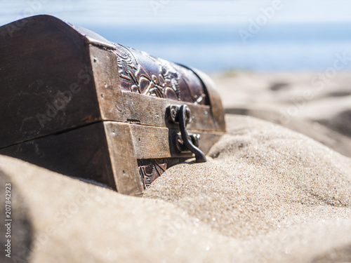 Fotografía close up locked chest in the sand on the beach