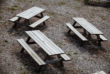 Three Empty Street Wooden Table With Benches On Either Side Of The Table. Outdoor Furniture, Summer Time Picnic Place For The Family Or Friends Company In The Park