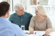 © New Africa - Mature couple discussing pension with consultant in office