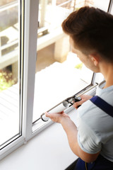 Sticker - Construction worker sealing window with caulk indoors