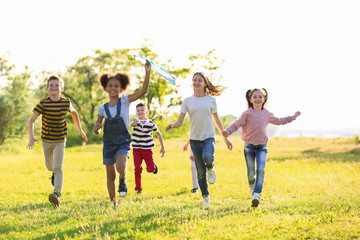 Sticker - Cute little children playing with kite outdoors on sunny day