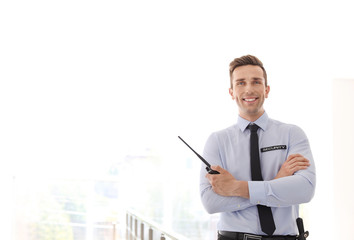 Male security guard with portable radio transmitter indoors