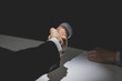 Business partners making handshake in dark shadow
