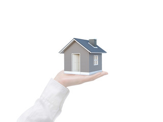 Fototapete - Simple house in human hand isolated on white background with clipping path. Image idea of real estate and property concept. House 3D render.