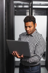 Tech support. Appealing IT guy using laptop and standing