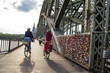 A couple on bicycles rides across the bridge to Cologne Cathedral