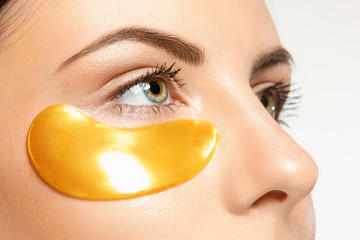 beauty portrait of an attractive girl with a gold patch under the eye.