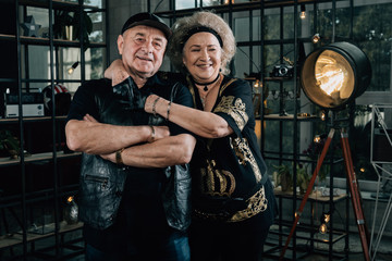 Wall Mural - Happy couple of retirees in biker clothes.Senior motorcyclist with a black helmet and goggles looking at the camera.Unusual retired couple.