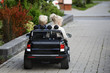 Boy and girl on toy electric car