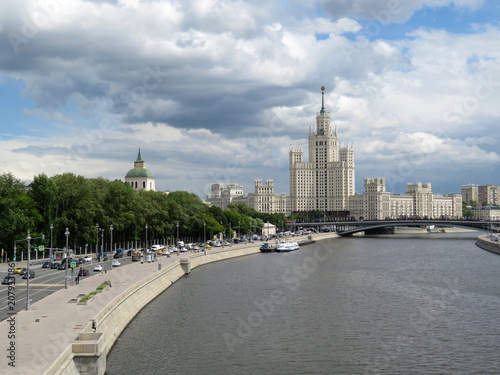Plakat Moskwa rzeka i wieżowiec Stalin w centrum stolicy Rosji. Moskwa centrum panorama przy dniem na tle chmurny niebo