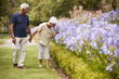 © Monkey Business - Senior Couple Holding Smelling Flowers On Walk In Park Together