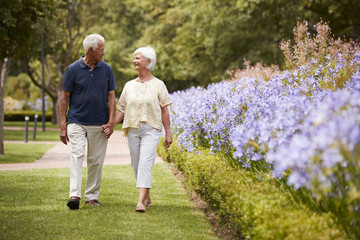 Wall Mural - Senior Couple Holding Hands On Romantic Walk In Park Together