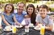 © Monkey Business - Portrait Of Family Enjoying Snack At Outdoor CafŽ Together