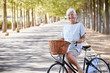 © Monkey Business - Portrait Of Smiling Senior Woman Cycling On Country Road